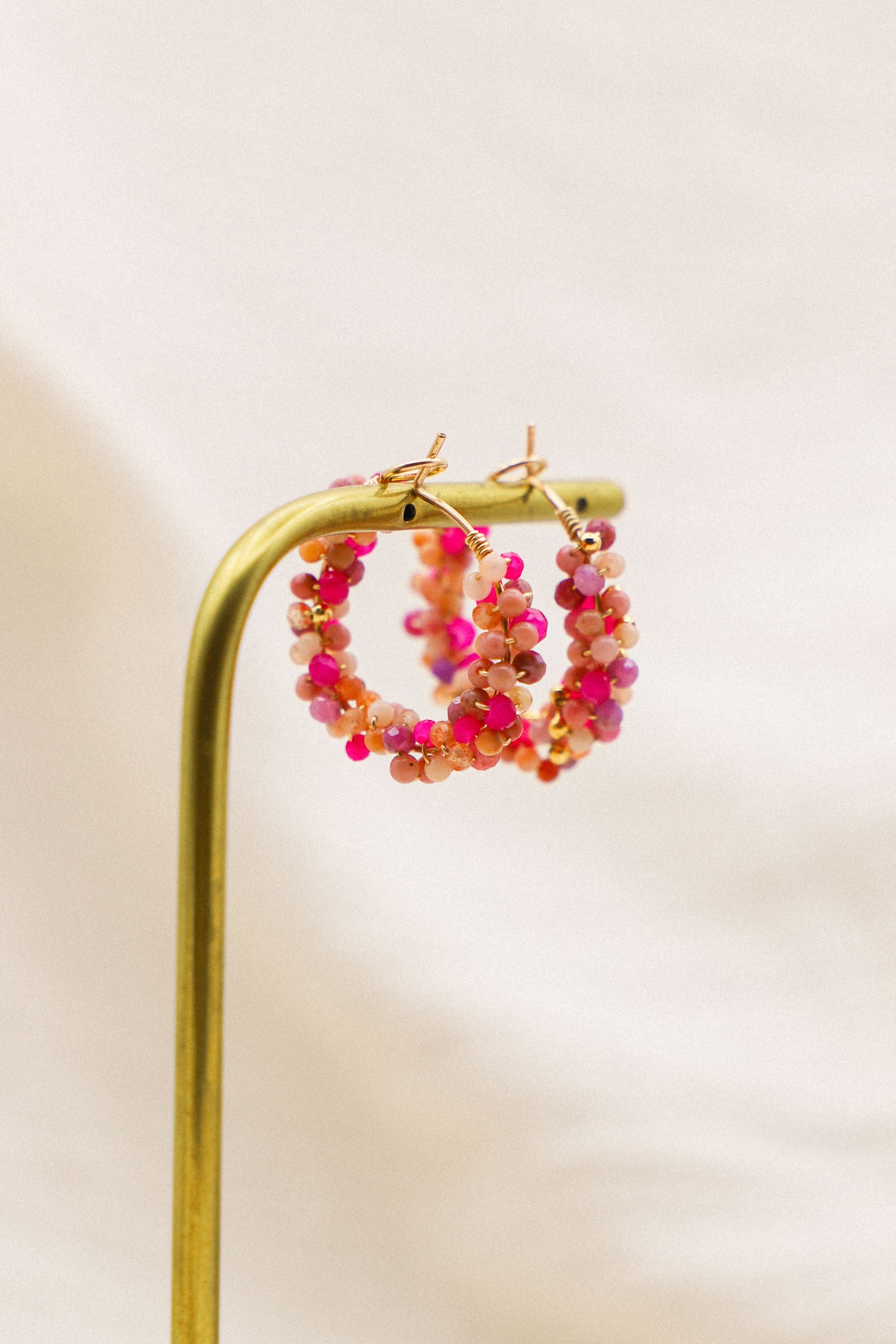 Boucles d'oreilles Jill, des créoles moyennes ornées de perles roses tissées.