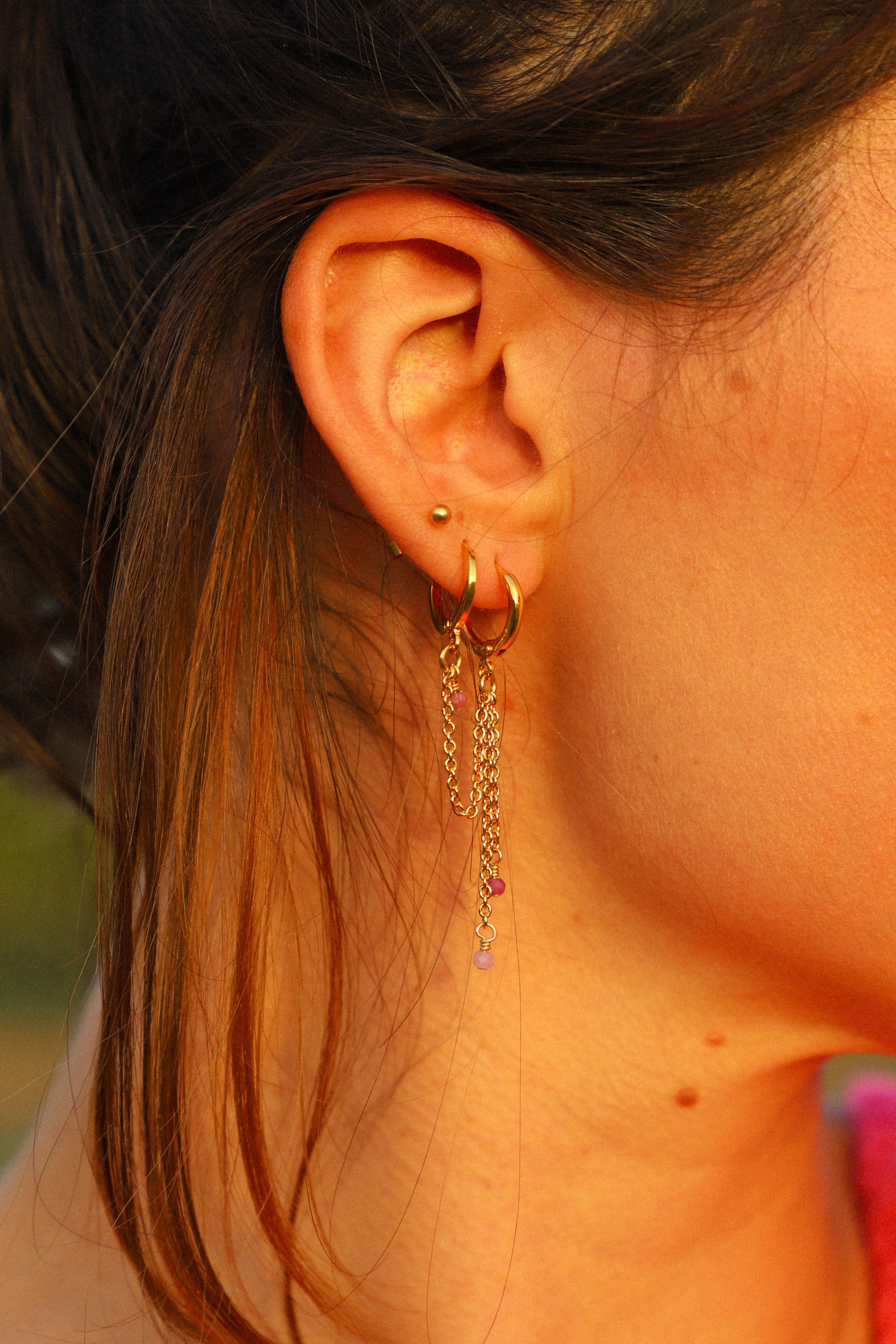 Double boucle d'oreille Nora. Une chaîne reliée et deux pendantes avec de petites perles roses.