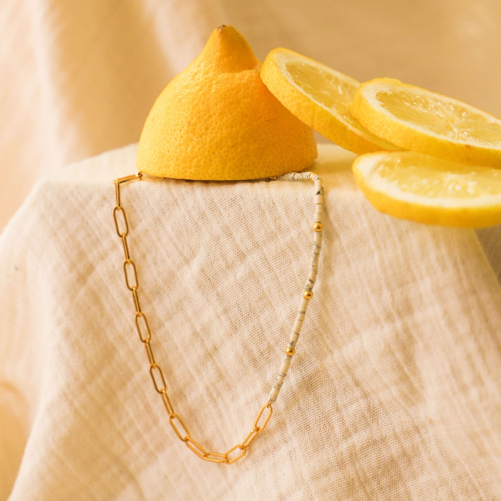 Bracelet de cheville Cara Mia. Bracelet asymétrique en chaine dorée et perles : heishi blanches et dorées.