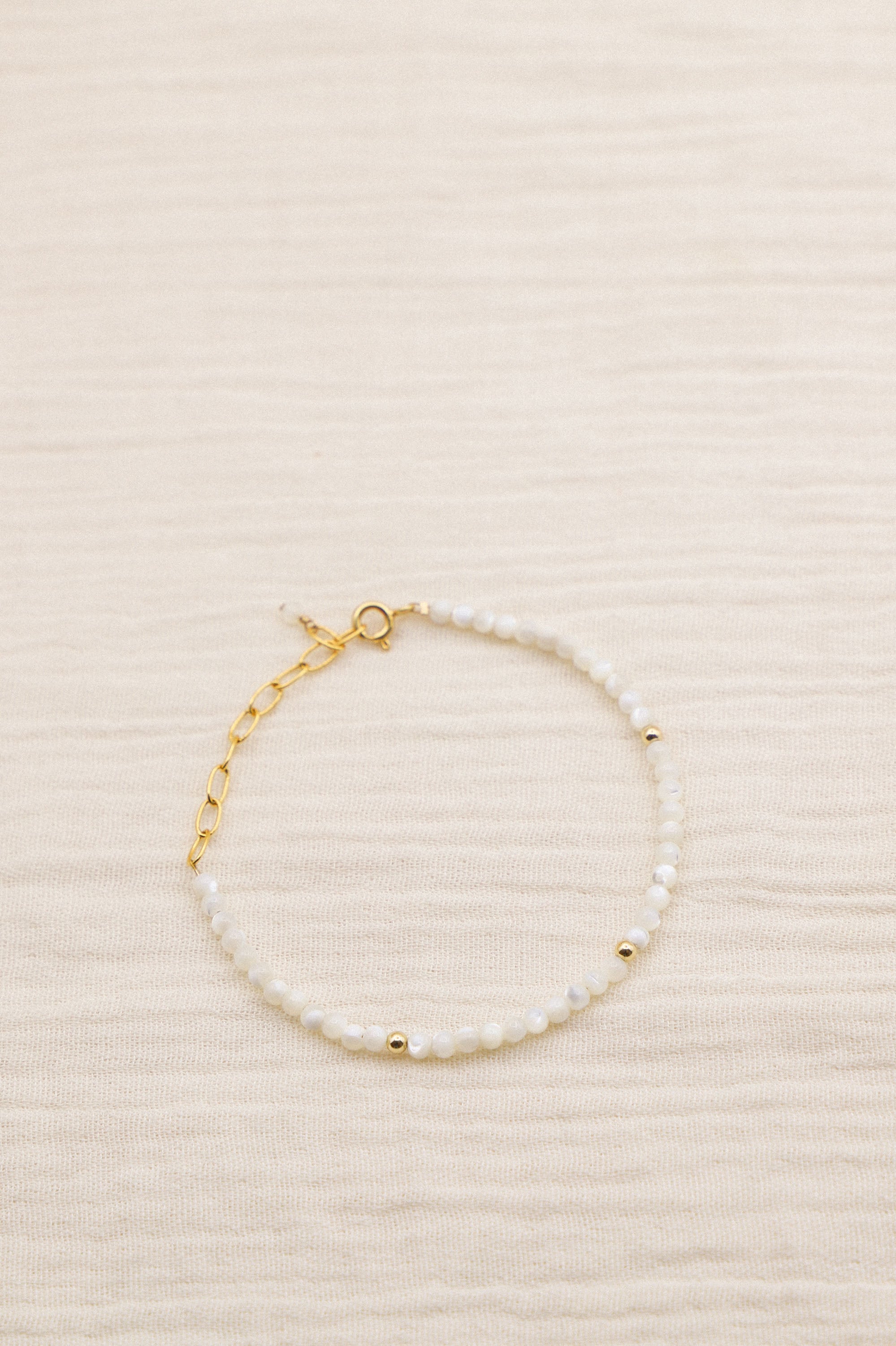 Bracelet June composé de perles blanches. Le tout, plaqué or 24 carats.