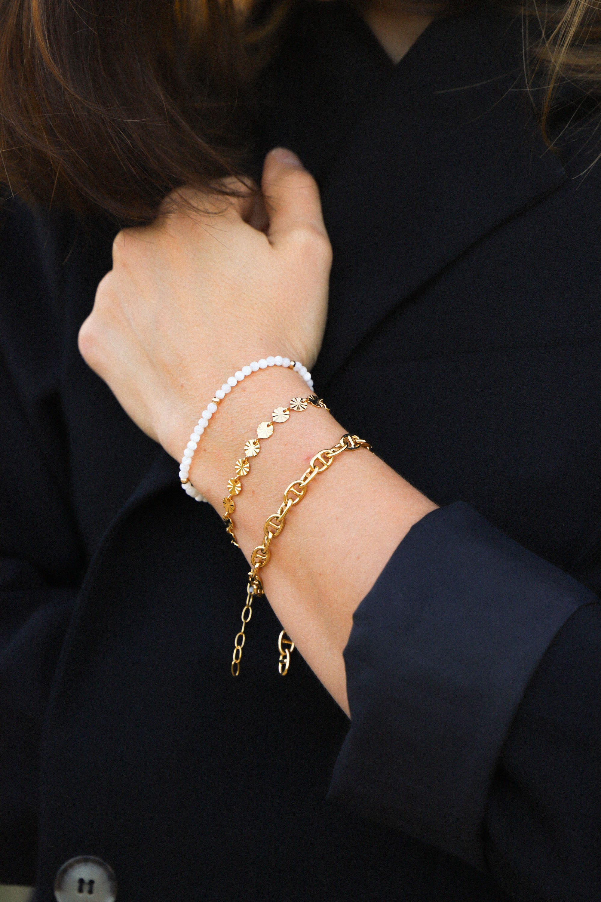 Bracelet June, ici porté, composé de perles blanches. Le tout, plaqué or 24 carats.