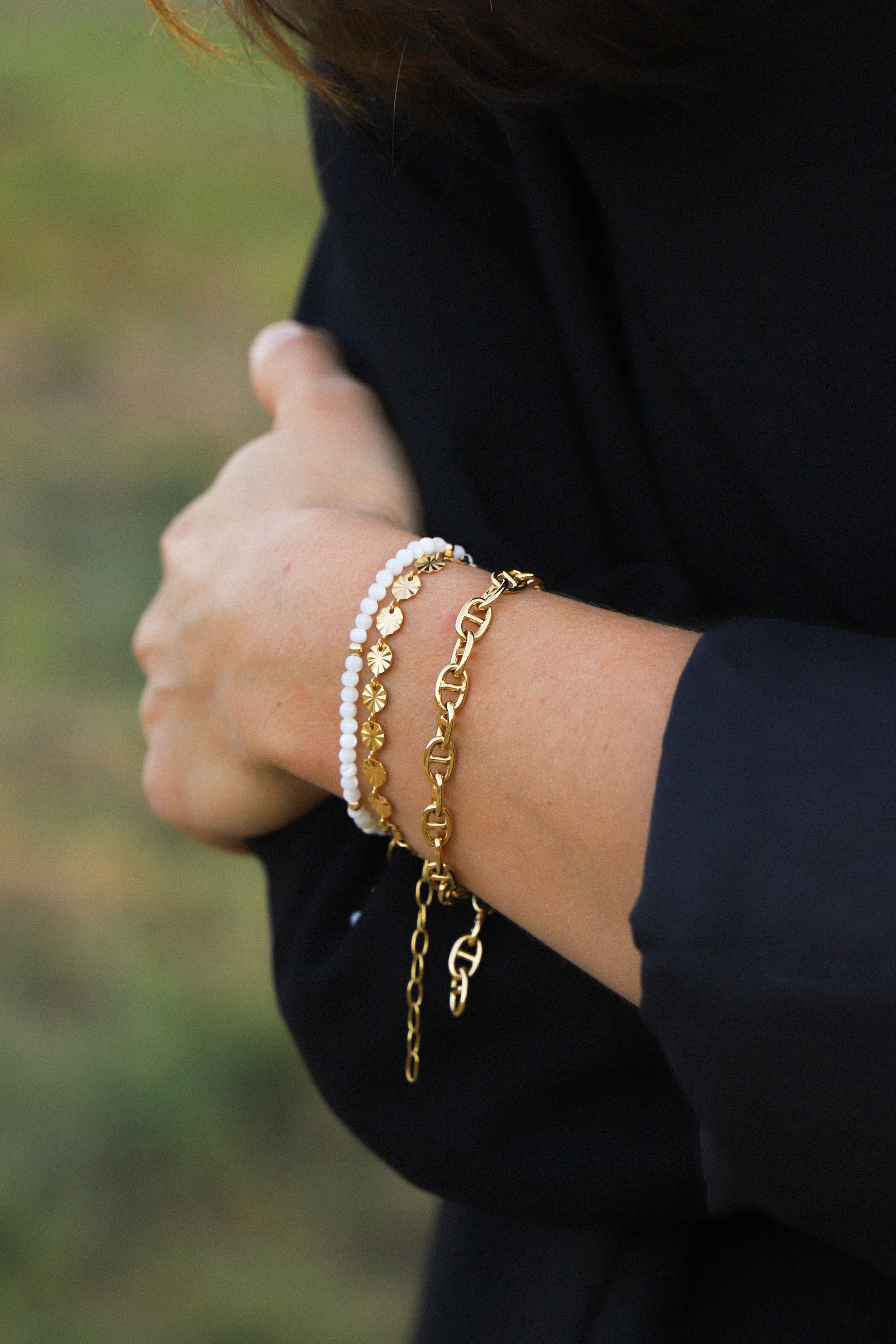 Bracelet Livia, ici porté, composé de mailles rondes et striées. Le tout, plaqué or 24 carats.