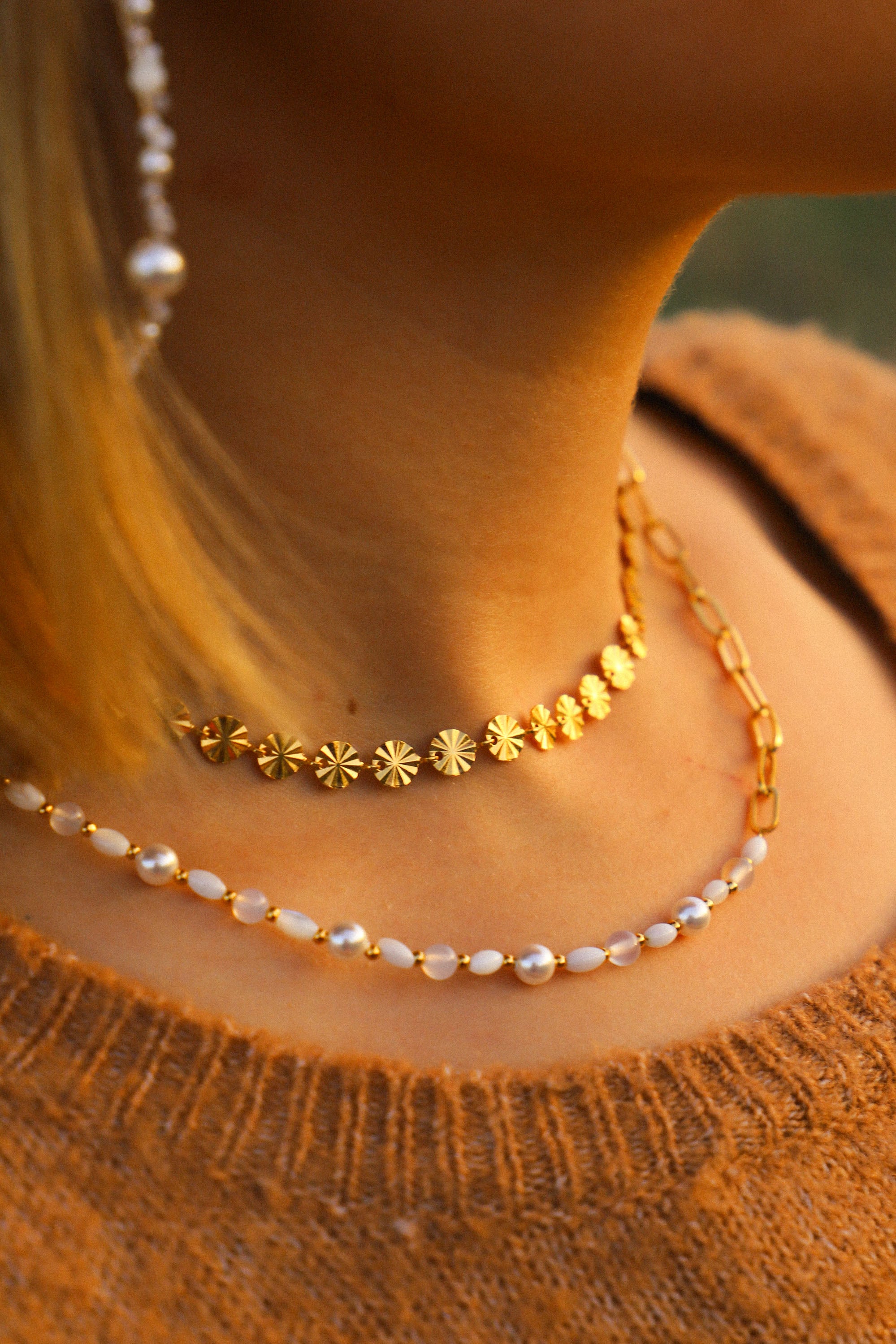 Collier Grace asymétrique, avec un côté perles et un côté chaîne. Les perles sont blanches et rythmées par de petites dorées.